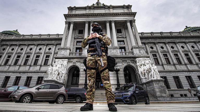 A member of the Pennsylvania Capitol Police stands guard at the entrance to the Pennsylvania Capitol Complex in Harrisburg, Pa., Wednesday, Jan. 13, 2021. (Jose F. Moreno / The Philadelphia Inquirer via AP)