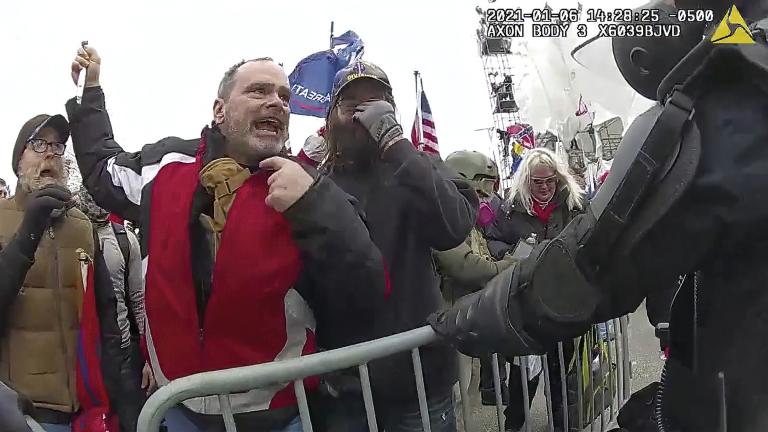 This still frame from Metropolitan Police Department body worn camera video shows Thomas Webster, in red jacket, at a barricade line at on the west front of the U.S. Capitol on Jan. 6, 2021, in Washington. (Metropolitan Police Department via AP)