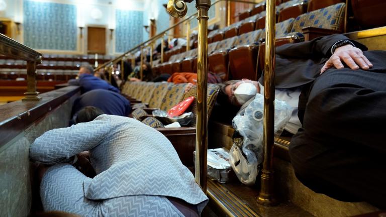 In this file photo, members of Congress and others shelter in the House gallery as rioters try to break into the House Chamber at the U.S. Capitol on Jan. 6, 2021, in Washington. (AP Photo/Andrew Harnik, File)