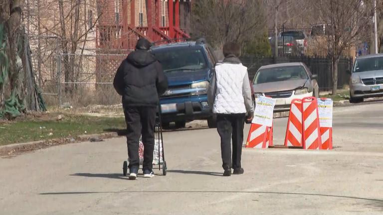 A couple walks along a street in Chicago’s Chatham neighborhood on Monday, April 6, 2020. (WTTW News)