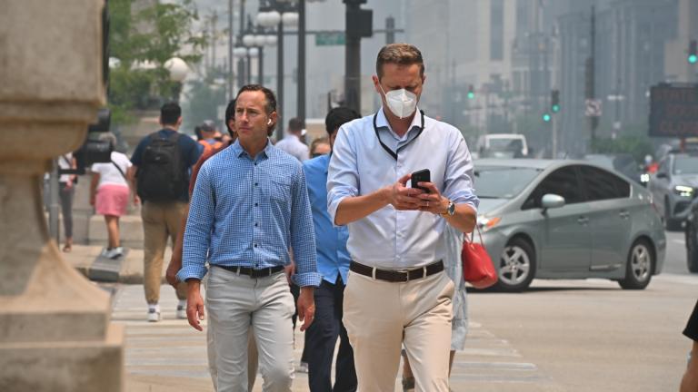 Pedestrians in downtown Chicago opt for masks amid hazardous air quality alerts on July 16, 2026. (Victor Hilitski / WTTW News)