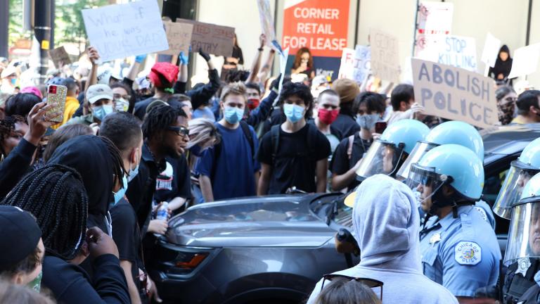 Protesters and police officers wearing riot gear have a standoff near Daley Plaza on Saturday, May 30, 2020. (Evan Garcia / WTTW News)