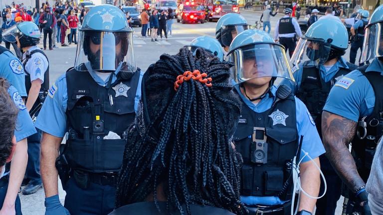 A protester faces off against police in Chicago on Saturday, May 30, 2020. (Hugo Balta / WTTW News)