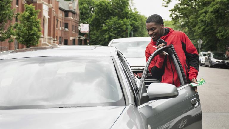 Anthony Perry, 20, looks over a car presented to him by Early Walker, founder of the organization I'm Telling Don't Shoot, Wednesday morning, June 8, 2022, in Chicago. (Pat Nabong / Chicago Sun-Times via AP)