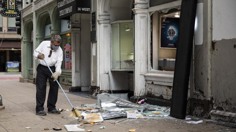 A man sweeps up outside Paul Young Fine Jewelers after looting broke out in the Loop and surrounding neighborhoods overnight, Monday morning, Aug. 10, 2020 in Chicago. (Ashlee Rezin Garcia / Chicago Sun-Times via AP)