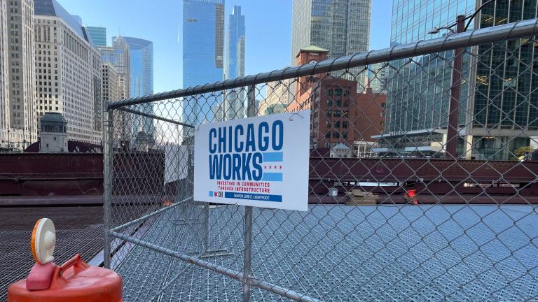 A Chicago Works sign hangs on the fence separating traffic from ongoing work to renovate the Dearborn Street bridge. (Heather Cherone/WTTW News)
