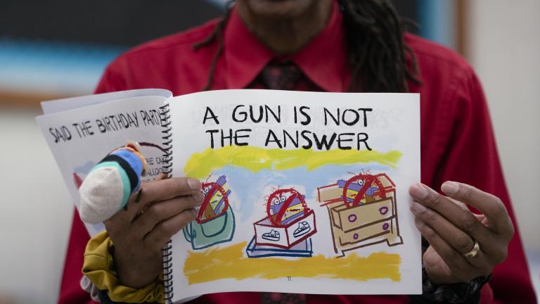 Ian Ellis James, an Emmy award-winning Sesame Street writer known by his stage name William Electric Black, leads a first grade class in a book reading on urban gun violence prevention at the Drexel Avenue School, Monday, Oct. 3, 2022, in Westbury, N.Y. (AP Photo/John Minchillo)