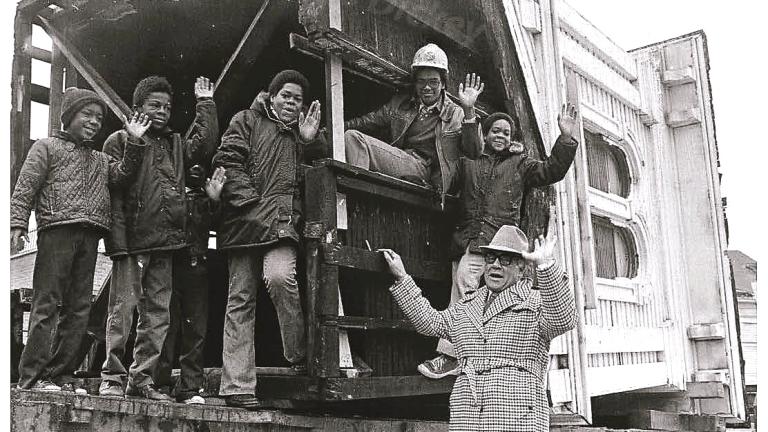 Bishop Louis Henry Ford and neighborhood children with the cupola of the Clarke House as the building was moved in 1977. (Courtesy of the Saint Paul Church of God in Christ archives)