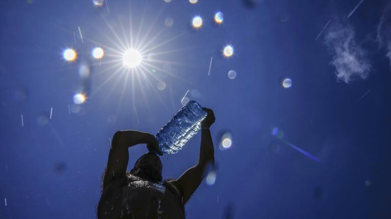 A man pours cold water onto his head to cool off on a sweltering hot day in the Mediterranean Sea in Beirut, Lebanon, July 16, 2023. (AP Photo / Hassan Ammar, File)