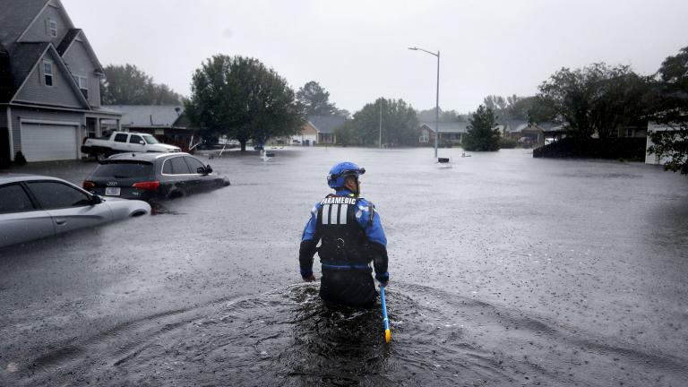 In this Sunday, Sept. 16, 2018 file photo, a member of the North Carolina Task Force urban search and rescue team wades through a flooded neighborhood looking for residents who stayed behind as Florence continues to dump heavy rain in Fayetteville, N.C. (AP Photo / David Goldman)