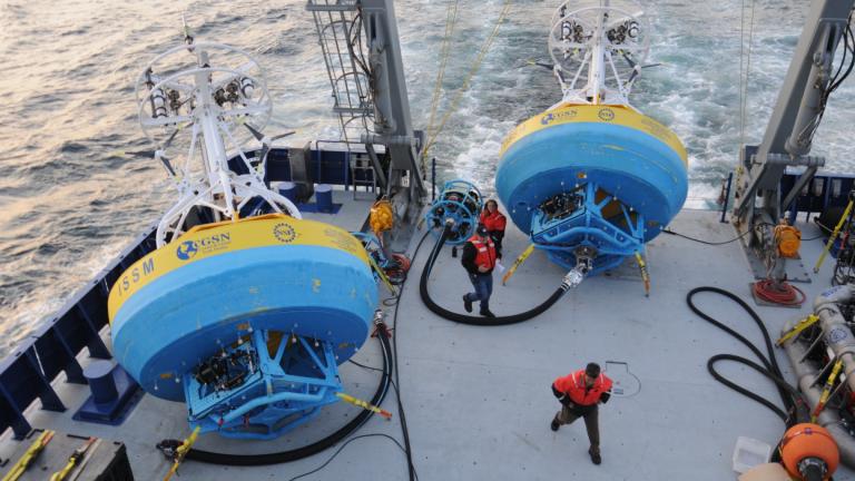 In this 2021 image provided by Woods Hole Oceanographic Institution, workers walk near buoys used to gather data at Pioneer New England shelf off the coast of Martha’s Vineyard, Mass. (Véronique LaCapra / Woods Hole Oceanographic Institution via AP)