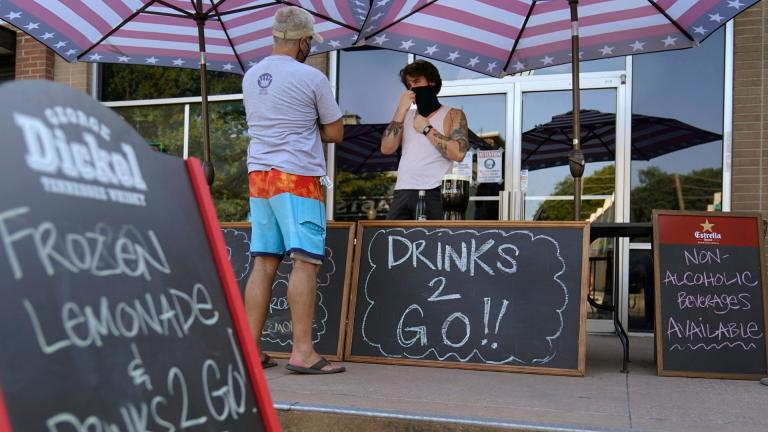 A drinks-to-go table is set up outside the Old Crow bar on Greenville Avenue in Dallas, Thursday, Aug. 13, 2020. Some states and cities in the U.S. are allowing cocktails to go due to the pandemic. (AP Photo / LM Otero) A drinks-to-go table is set up outside the Old Crow bar on Greenville Avenue in Dallas, Thursday, Aug. 13, 2020. Some states and cities in the U.S. are allowing cocktails to go due to the pandemic. (AP Photo / LM Otero)