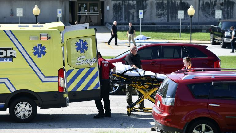 Medical personnel load the body of one victim as a second deceased victim awaits following a shooting near the Kankakee County Courthouse, Thursday morning, Aug. 26, 2021, in Kankakee, Ill. (Tiffany Blanchette / The Daily Journal via AP)