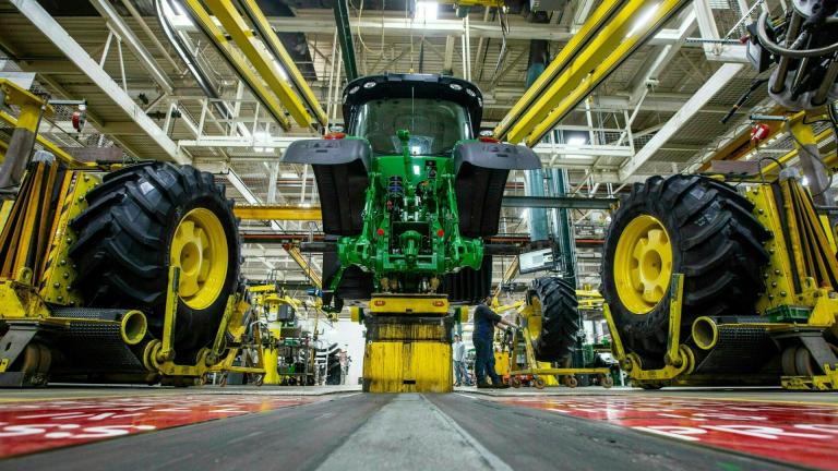 In this April 9, 2019, wheels are attached as workers assemble a tractor at John Deere's Waterloo, Iowa assembly plant. (Zach Boyden-Holmes / Telegraph Herald via AP, File)