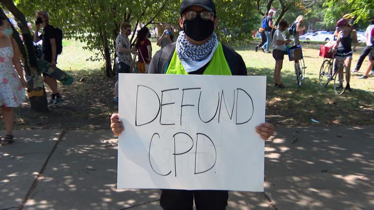 A youth activist holds a sign as part of a peaceful march to Mayor Lori Lightfoot’s home on Aug. 13, 2020 to demand the removal of resource officers from Chicago Public Schools. (WTTW News)