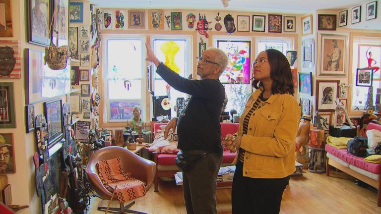 Patric McCoy shows WTTW arts correspondent Angel Idowu his art collection. (WTTW News)