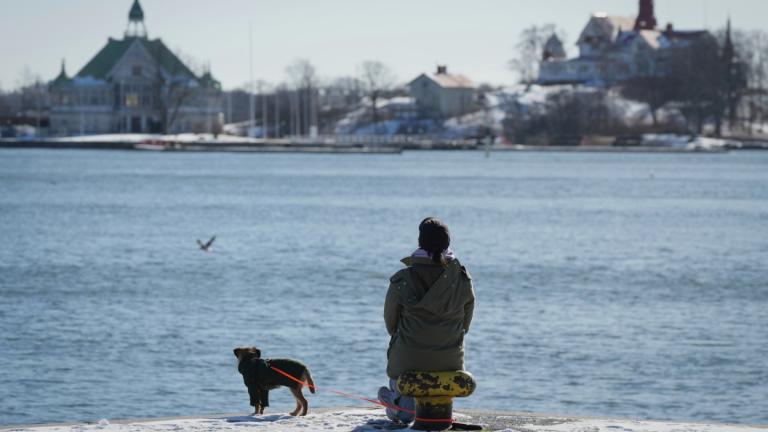 A woman enjoys a sunny and frosty day on the embankment of the South Harbour in Helsinki, Finland, Saturday, March 15, 2025. (AP Photo/Sergei Grits)