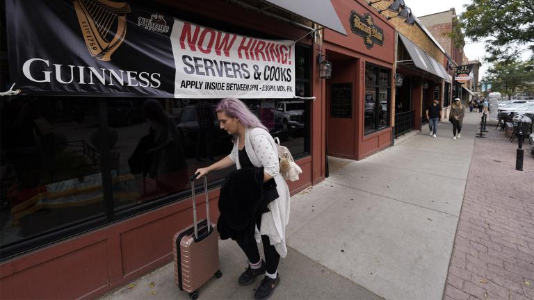 A traveller wheels her baggage past a now hiring sign outside a bar and restaurant Saturday, Oct. 9, 2021, in Sioux Falls, S.D. (AP Photo / David Zalubowski) 