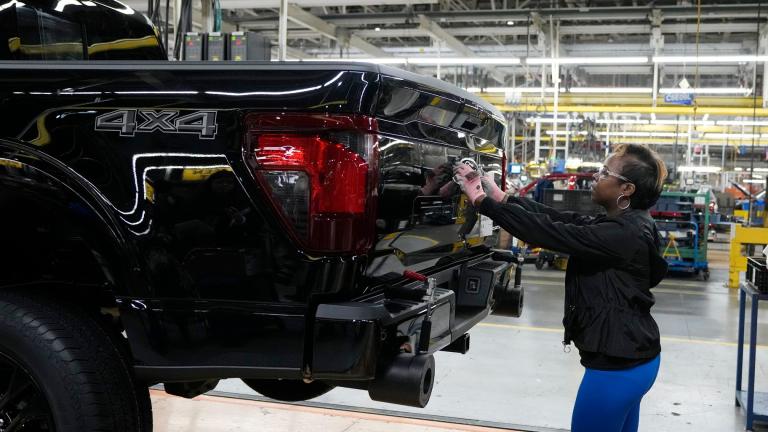 Assembly line worker Lashunta Harris applies the Ford logo on a 2024 Ford F-150 truck being assembled at the Dearborn Truck Plant, April 11, 2024, in Dearborn, Mich. (AP Photo / Carlos Osorio, File)