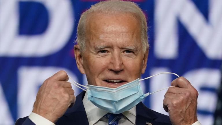 Democratic presidential candidate former Vice President Joe Biden takes off his face mask as he arrives to speak, Wednesday, Nov. 4, 2020, in Wilmington, Del. (AP Photo/Carolyn Kaster)
