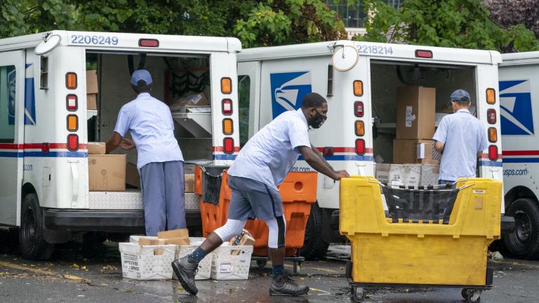 In this July 31, 2020, file photo, letter carriers load mail trucks for deliveries at a U.S. Postal Service facility in McLean, Va. The success of the 2020 presidential election could come down to a most unlikely government agency: the U.S. Postal Service. (AP Photo/J. Scott Applewhite, File)