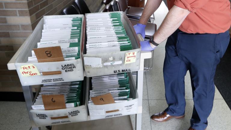 In this May 5, 2020, file photo, absentee ballots to be counted are moved at City Hall in Garden City, Mich. Data obtained by The Associated Press shows Postal Service districts across the nation are missing the agency’s own standards for on-time delivery as millions of Americans prepare to vote by mail. (AP Photo/Paul Sancya, File)