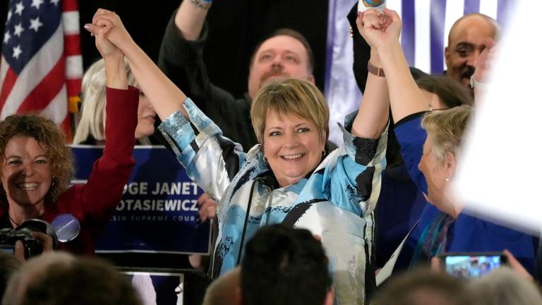 Supreme Court candidate Janet Protasiewicz, center, holds hands with Wisconsin Supreme Court Justice, Rebecca Dallet, far left, and Wisconsin Supreme Court Justice Ann Walsh Bradley, right, at Protasiewicz's election night watch party in Milwaukee, Wis., on Tuesday, April 4, 2023. (Mike De Sisti  / Milwaukee Journal-Sentinel via AP)