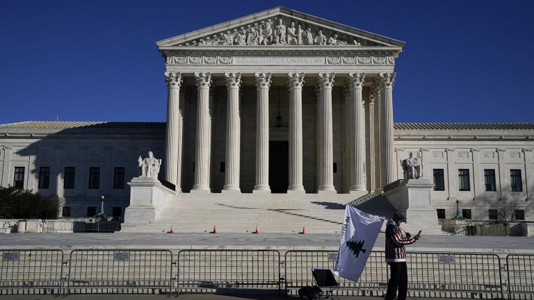 A person walks by newly-placed barricades around the Supreme Court Building, the day after violent protesters loyal to President Donald Trump stormed the U.S. Congress in Washington, Thursday, Jan. 7, 2021. (AP Photo / Evan Vucci)