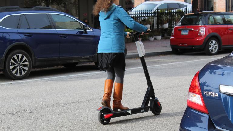 A woman rides an electric scooter in Baltimore on Nov. 18, 2018. (Elvert Barnes / Flickr) 
