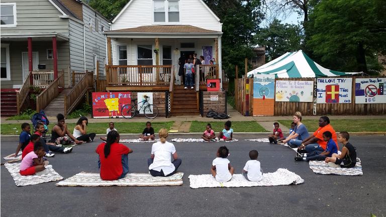 Participants take part in street yoga outside the Peace House, a community center in Englewood built by the nonprofit group I Grow Chicago. (Courtesy of Erin Vogel)