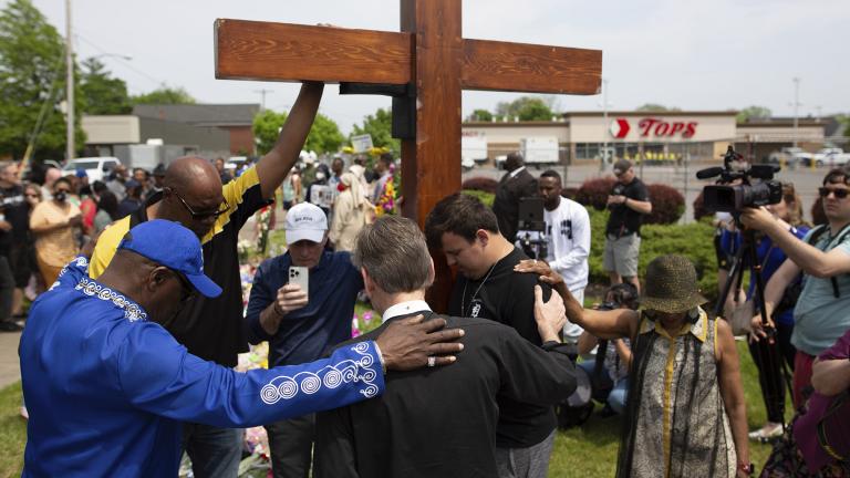 A group prays at the site of a memorial for the victims of the Buffalo supermarket shooting outside the Tops Friendly Market on May 21, 2022, in Buffalo, N.Y. (AP Photo / Joshua Bessex, File)