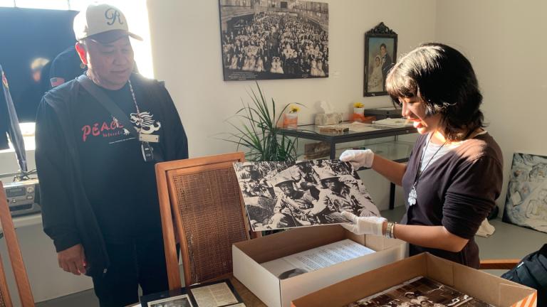 Filipino American Historical Society of Chicago President Ruben Salazar, left, and exhibit curator and FAHSC board member Reese Carolina Cuison Villazor, right, prepare the “Chicago in Quotas and Communities” exhibit at the organization’s museum space in Mana Contemporary on Oct. 16, 2025. (Eunice Alpasan / WTTW News)