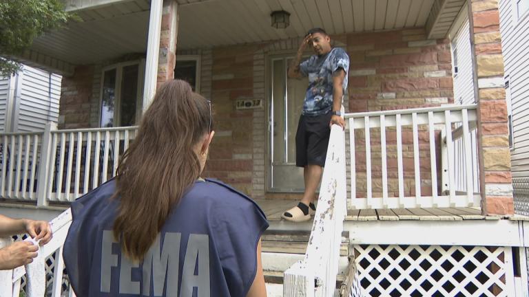 A team member with the Federal Emergency Management Agency speaking to a resident in Cicero, Ill., on July 26, 2023. (WTTW News)