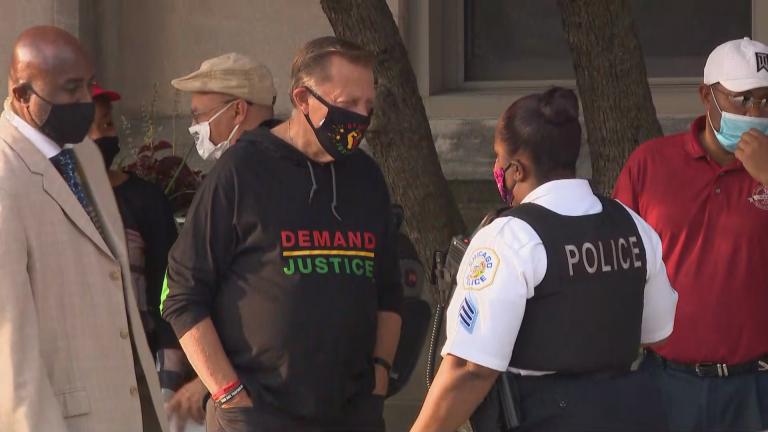 The Rev. Michael Pfleger speaks with a Chicago police officer outside St. Sabina Church during a protest over the grand jury decision in the Breonna Taylor case on Wednesday, Sept. 23, 2020. (WTTW News)
