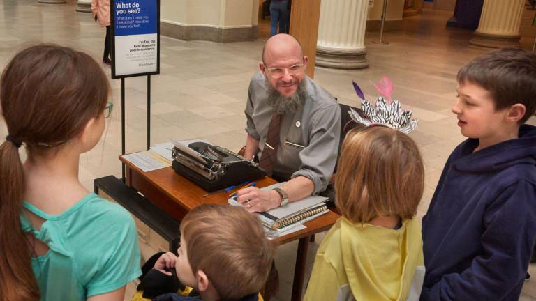 Eric Elshtain, the Field Museum’s first-ever poet-in-residence, interacts with a group of children in the museum’s Stanley Field Hall. (John Weinstein / The Field Museum)