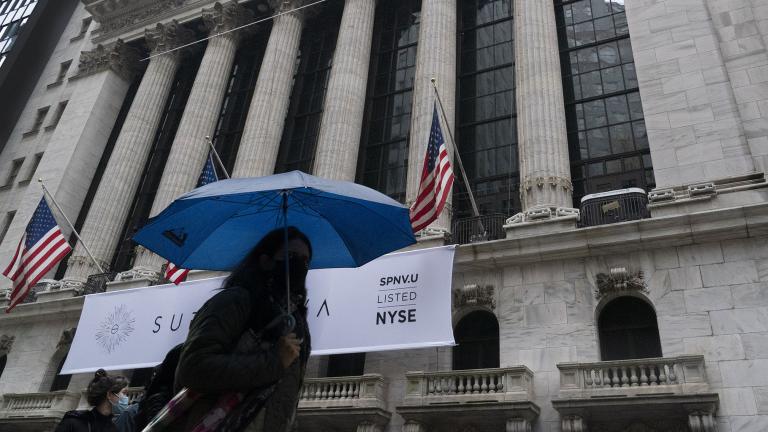 A woman with an umbrella passes the New York Stock Exchange, Monday, Oct. 26, 2020. (AP Photo / Mark Lennihan)
