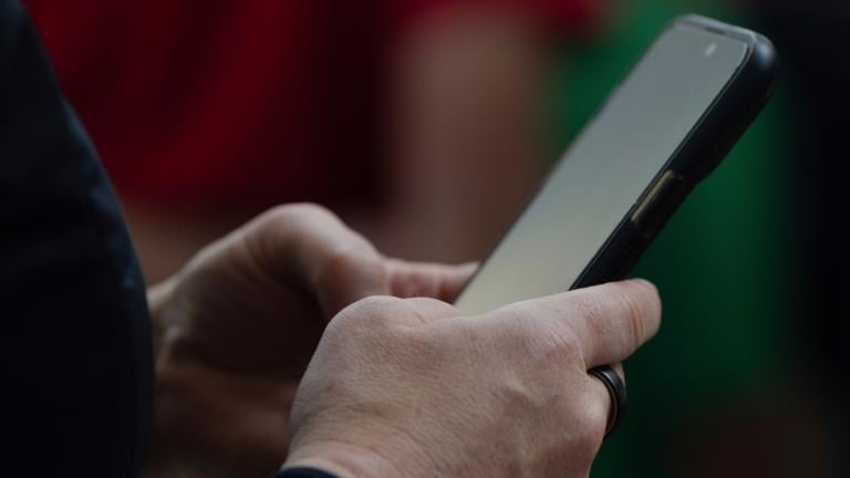 FILE - A person looks at their phone at Seattle–Tacoma International Airport on Sunday, June 1, 2025, in Seattle. (AP Photo / Jenny Kane, File)