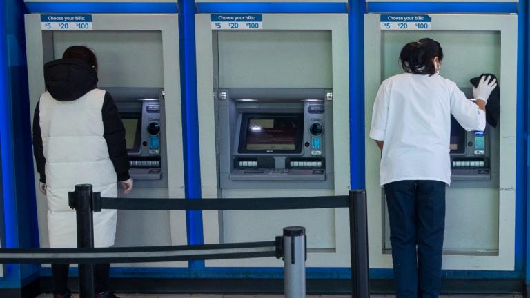 FILE - A customer makes a transaction at a bank of automatic teller machines in the Queens borough of New York on March 24, 2020. (Mary Altaffer / AP Photo, File)