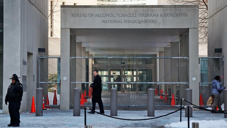 A security official walks in front of the entrance to the national headquarters of the Bureau of Alcohol, Tobacco, Firearms and Explosives on Jan. 23, 2014, in Washington. (AP Photo / Charles Dharapak, File)