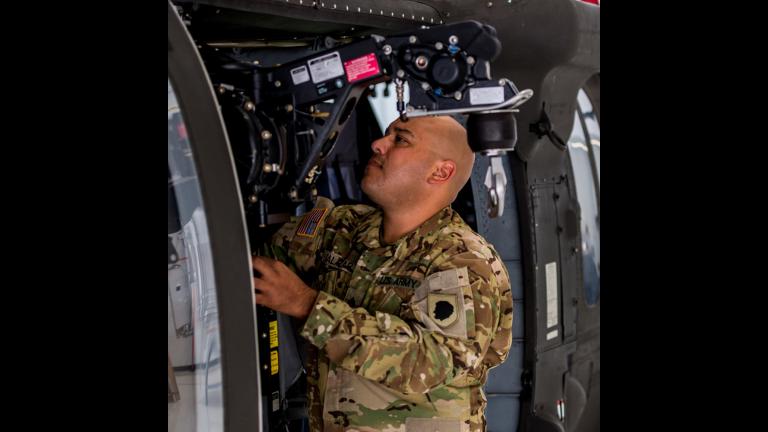 Sgt. Andres Salazar inspects an internal hoist on the UH-60 Blackhawk helicopter at the Kankakee Army Aviation Support Facility on Sept. 12, 2018. (Sgt. Stephen Gifford / Illinois National Guard)