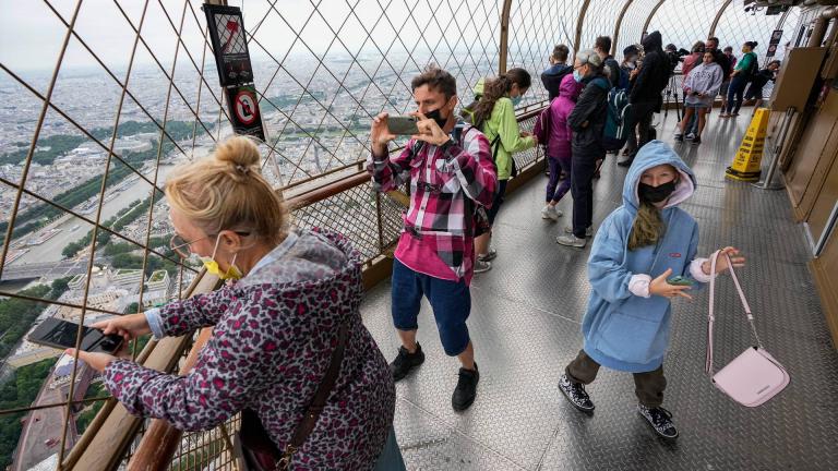 In this Friday, July 16, 2021 file photo, visitors enjoy the view from top of the Eiffel Tower in Paris. (AP Photo / Michel Euler, File)