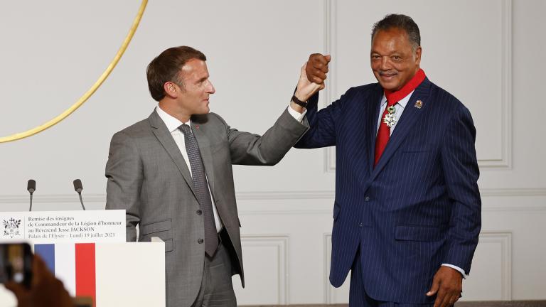 French President Emmanuel Macron, left, and Reverend Jesse Jackson raise their hands after Jackson was awarded with the Legion d’Honneur (Officer of the Legion of Honor) medal during a ceremony at the Elysee Palace in Paris, Monday, July 19, 2021. (Ludovic Marin / Pool Photo via AP)