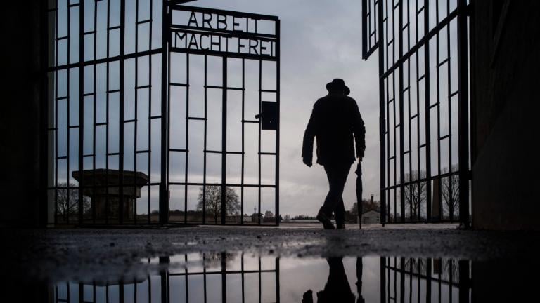 A man walks through the gate of the Sachsenhausen Nazi death camp with the phrase ‘Arbeit macht frei’ (work sets you free) at the International Holocaust Remembrance Day, in Oranienburg, Germany, on Jan. 27, 2019. (AP Photo / Markus Schreiber, File)