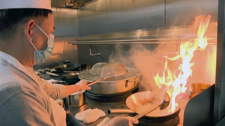 An employee of Dai Yee’s Asian Kitchen cooks noodles in a wok on Mar. 2, 2021 at CloudKitchens. Dai Yee’s is one of 10 restaurants renting a kitchen from the ghost kitchen located in Chicago’s North Center neighborhood. (WTTW News)