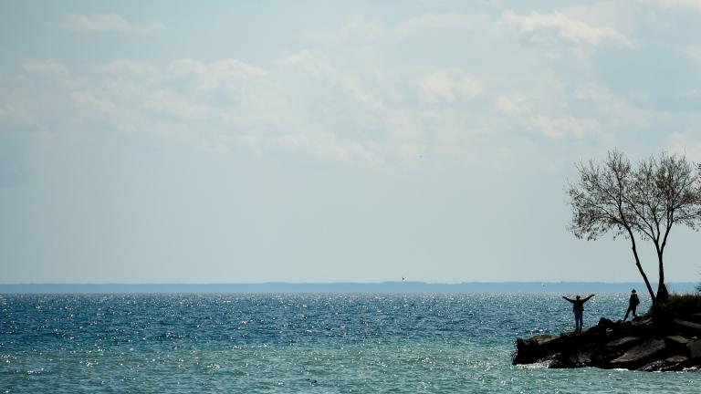 FILE - People are silhouetted as they look out over Lake Ontario in Toronto, April 27, 2020. (Nathan Denette / The Canadian Press via AP, File)
