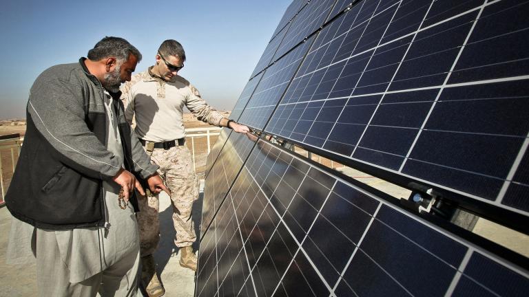 Maj. Erich Bergiel, right, inspects the solar panels on the roof of the Marjeh Fruit and Vegetable Packing Facility in Afghanistan while he talks with Abdul Rahman, a renewable energy engineer. (Master Gunnery Sgt. Phil Mehringer / U.S. Department of Defense) 
