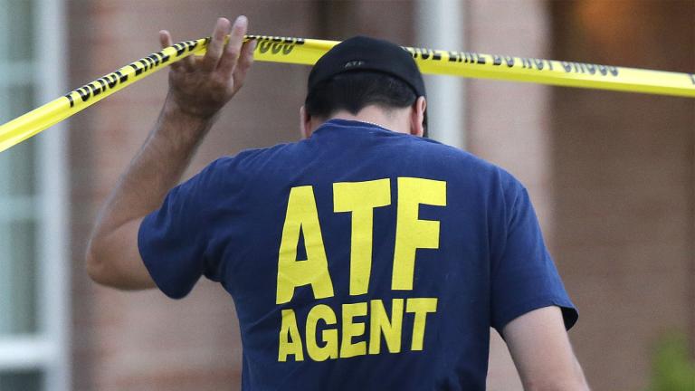 An ATF agent lifts crime scene tape, Aug. 8, 2013, in DeSoto, Texas. (AP Photo / LM Otero, File)