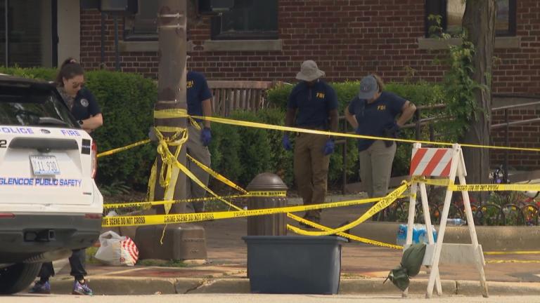 FBI investigators examine the scene in downtown Highland Park on July 5, 2022, a day after a mass shooting occurred at the Fourth of July parade. (WTTW News)