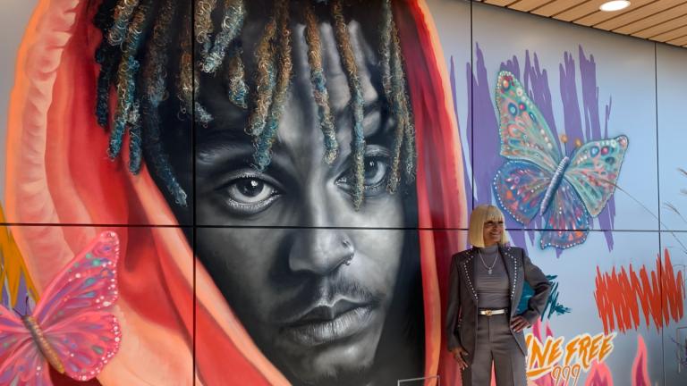 The mother of late rapper Juice WRLD Carmela Wallace in front of a mural of her son at Homewood Brewing Company on Oct. 18, 2024. (Eunice Alpasan / WTTW News)