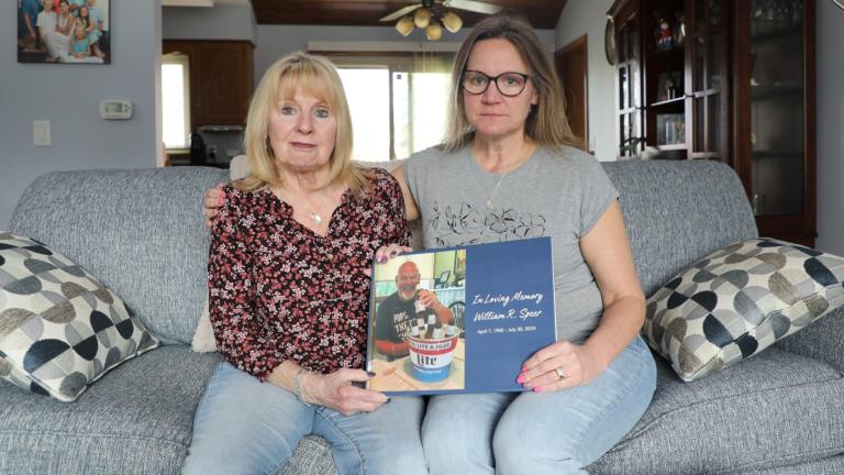 Boni Speer, left, and her daughter, Tracy Balhan, hold a photo of Bill Speer, Tracy’s father, in Aurora, Ill., on Friday, March 14, 2025. (Benjamin Thorp / WFYI Public Media via AP)